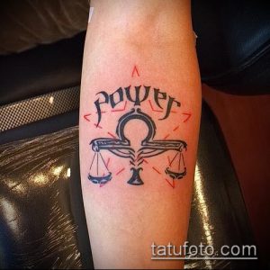 Фото тату Весы на ноге: весы с надписью 'Power' и красными акцентами, выполненные в минималистичном стиле.