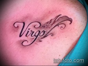 Фото татуировки на ключице с надписью "Virgo" выполненной красивым шрифтом. Рисунок татуировки дополнен небольшим растительным орнаментом.