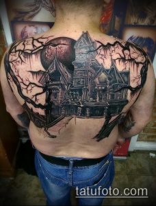 Фото тату: детализированный рисунок старинного особняка на фоне луны и деревьев на спине, выполненный в реалистичном стиле.