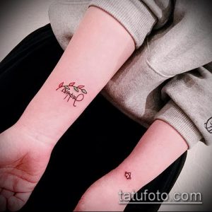 Фото тату: миниатюрная надпись "Darling" с веточкой листьев на женском запястье. Нежный и изящный рисунок татуировки выполнен тонкими линиями.