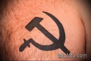Фото татуировки серпа и молота на груди, выполненной в простом, черно-белом стиле.