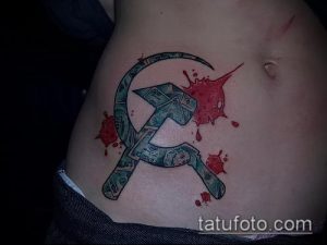 Фото тату на животе с изображением серпа и молота, окруженных брызгами крови. Цветной рисунок татуировки в стиле гранж.