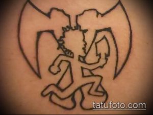 Фото черно-белой татуировки персонажа Violent J из Insane Clown Posse с крыльями, выполненной в минималистичном стиле.