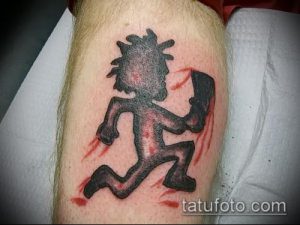 Фото тату с изображением персонажа Violent J из Insane Clown Posse на плече, выполненное в черном цвете с красными брызгами.