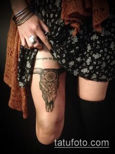 Фото тату черепа быка в стиле dotwork, расположенного на бедре. Детализированный черно-белый рисунок.