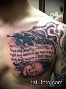 Фото татуировки на груди с изображением солдата, девушки и надписи 'People sleep peacefully...', выполненной в реалистичном стиле с использованием черных и серых оттенков.