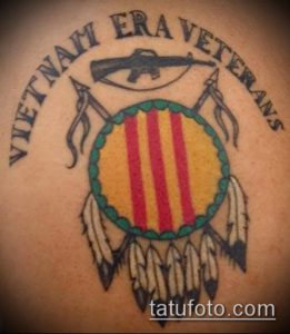 Фото тату на плече с изображением флага Южного Вьетнама, оружия и надписи 'Vietnam Era Veterans'. Патриотичный рисунок для ветеранов.