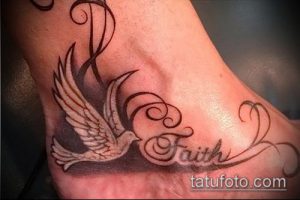Фото тату голубя с надписью 'Faith' на стопе. Детализированный рисунок татуировки в черно-серых тонах.