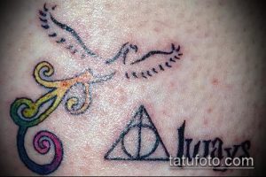 Фото тату на коже: Дары Смерти, феникс и надпись 'Always' в ярких цветах. Композиция с использованием различных стилей татуировки.