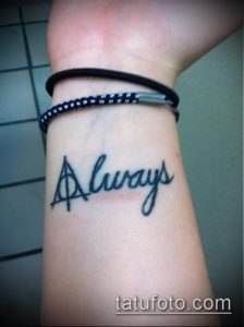 Фото тату надписи 'Always' с символом Даров Смерти на запястье. Черно-белый рисунок татуировки, выполненный тонкой линией.