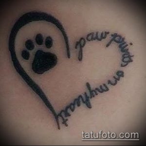 Фото тату отпечатка лапы, заключенного в форму сердца, с надписью 'paw prints forever'. Черно-белая татуировка.