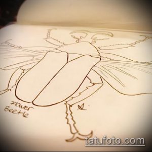 Простой эскиз татуировки с изображением жука, выполненный тонкими линиями. Рисунок выглядит как набросок карандашом на бумаге.