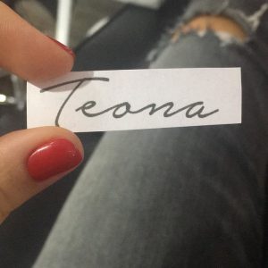 Фотография эскиза татуировки с надписью "Teona", выполненной каллиграфическим шрифтом. Идеально для персонализированной татуировки.