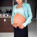 Фото тату на животе беременной женщины, изображающее ветви дерева. Нежный и символичный рисунок.