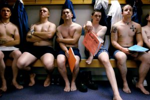 Фото группы заключенных с татуировками на руках, груди и шее. Разнообразие тюремных татуировок и их символики.