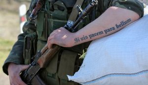 Фото тату на руке военнослужащего: латинская фраза 'Si vis pacem, para bellum'. Четкая проработка букв и символов.