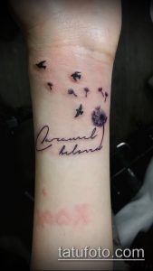 Фото тату: Нежная татуировка с изображением одуванчика и надписи "Dream and beloved" на запястье. Романтичный и символичный дизайн.