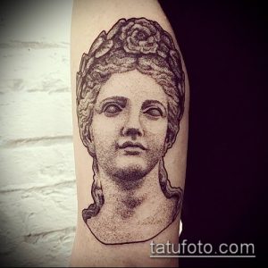 Фото тату с изображением головы античной богини в точечном стиле (dotwork). Детализированный рисунок татуировки на предплечье, выполненный в черно-белой гамме.