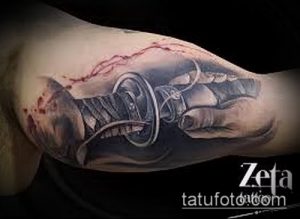 Фото реалистичного тату катаны, пронзающей кожу. Черно-серый рисунок с детальной проработкой текстур и эффектом кровотечения.