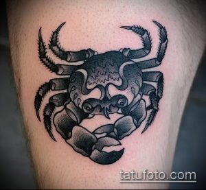Фото минималистичной татуировки краба на ноге в технике blackwork. Рисунок выполнен только черными линиями и точками, создавая эффект графичности и контраста.