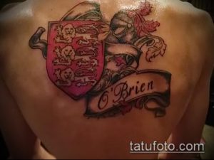 Фото татуировки с изображением ирландского герба и фамилии 'O'Brien' на спине. Детализированный рисунок в традиционном стиле.