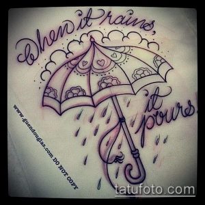 Фото тату на руке с изображением зонтика, украшенного цитатой "When it rains, it pours". Рисунок татуировки в стиле олд скул.