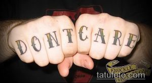 Фото тату на костяшках пальцев с надписью DON'T CARE. Простой шрифт, яркие цвета, дерзкий стиль.