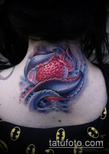 Фото акварельной татуировки клубники на спине. Нежный рисунок татуировки с размытыми краями и яркими цветовыми переходами.