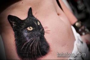 Фото тату реалистичного портрета черного кота на груди. Детализированный рисунок, реализм, животное.