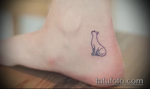 Маленькая татуировка сидящей кошки, выполненная в тонких линиях на лодыжке. Минималистичный и женственный рисунок.