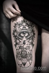 Фото тату на бедре: глаз в треугольнике, окруженный геометрическими фигурами и точками. Черно-белый рисунок татуировки в стиле геометрия.