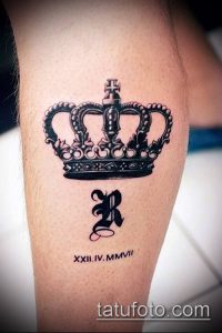 Фото татуировки с изображением короны и римскими цифрами XXII.IV.MMVII на ноге мужчины. Стильный и оригинальный рисунок татуировки.