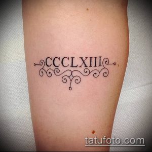 Фото татуировки с римскими цифрами CCCLXIII, обрамленными декоративными завитками. Изящный и женственный рисунок татуировки.