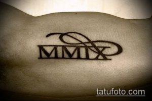 Фото тату: черные римские цифры 'MMIX' внутри символа бесконечности на коже. Символизирует вечную любовь и память.