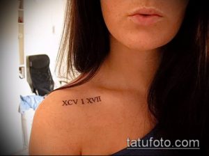 Фото тату: черные римские цифры 'XCV I XVII' на ключице, выполненные тонкой линией. Элегантный и женственный дизайн.