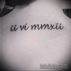 Фото татуировки на задней части шеи с римскими цифрами ii vi mmxxii. Тонкие линии, минималистичный дизайн.
