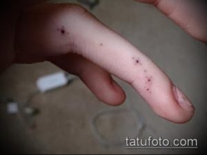 Фото татуировки в виде нескольких точек на пальце руки. Минималистичный и необычный рисунок татуировки.