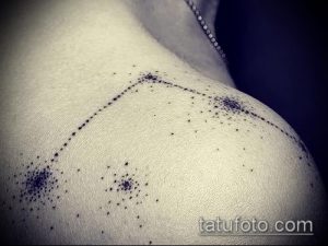 Фото тату созвездия на плече. Рисунок выполнен тонкими линиями, образующими контур созвездия. Несколько ярких точек выделяют ключевые звезды.