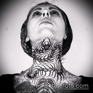 Фото тату скорпиона, выполненного в технике blackwork, на шее женщины. Рисунок охватывает всю область шеи и частично переходит на плечи.