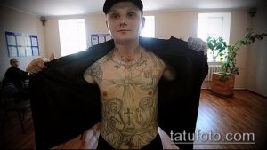 Фото тату масштабной композиции на теле, включающей изображения Богоматери, крестов и куполов, выполненное в черно-серых тонах.