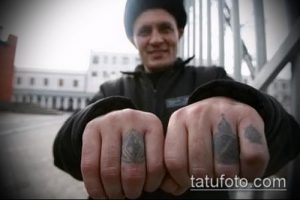 Фотография рук с миниатюрными татуировками на пальцах, изображающими архитектурные элементы. Небольшие, но выразительные рисунки.