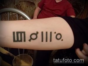 Фото тату: минималистичная татуировка, состоящая из геометрических фигур и символа Венеры, на предплечье руки.