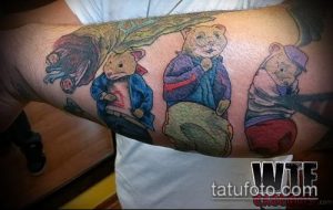 Фото тату с изображением трех мишек в одежде: в синих куртках и кепках. Рисунок выполнен в ярких цветах на руке.