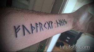 Фото тату: руническая надпись на предплечье, выполненная в черно-белом цвете. Древние символы образуют защитный амулет.