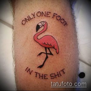 Фото тату на ноге: розовый фламинго с надписью "ONLY ONE FOOT IN THE SHIT". Необычный и юмористический рисунок татуировки.