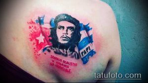 Фото тату: портрет Че Гевары на груди с флагом Кубы и надписью на испанском языке, выполненный в ярких и насыщенных цветах.