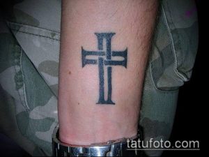 Фото тату: простой крест на запястье. Черно-серая татуировка с четкими линиями. Минималистичный рисунок татуировки, подходящий для первого тату.