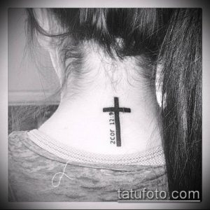 Фото тату: крошечный крест на затылке с надписью "2 Cor 12:9". Небольшой и изящный рисунок татуировки.