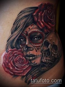Фото тату женского лица в стиле Sugar Skull с изображением черепа и роз. Красные и черные оттенки, детальная прорисовка.
