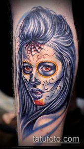 Фото тату женского лица в стиле Sugar Skull на голени. Голубые и красные оттенки, паутина, детальная прорисовка.